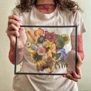 Woman holding framed pressed flowers